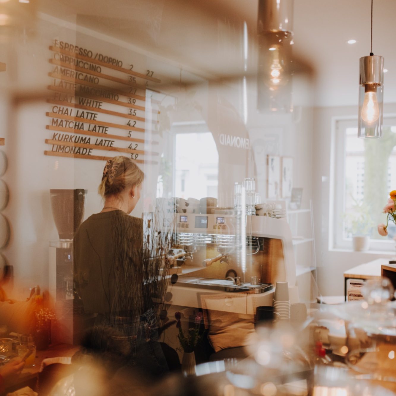 Barista im Café Palena bereitet Cappuccino mit perfekter Latte Art zu.
